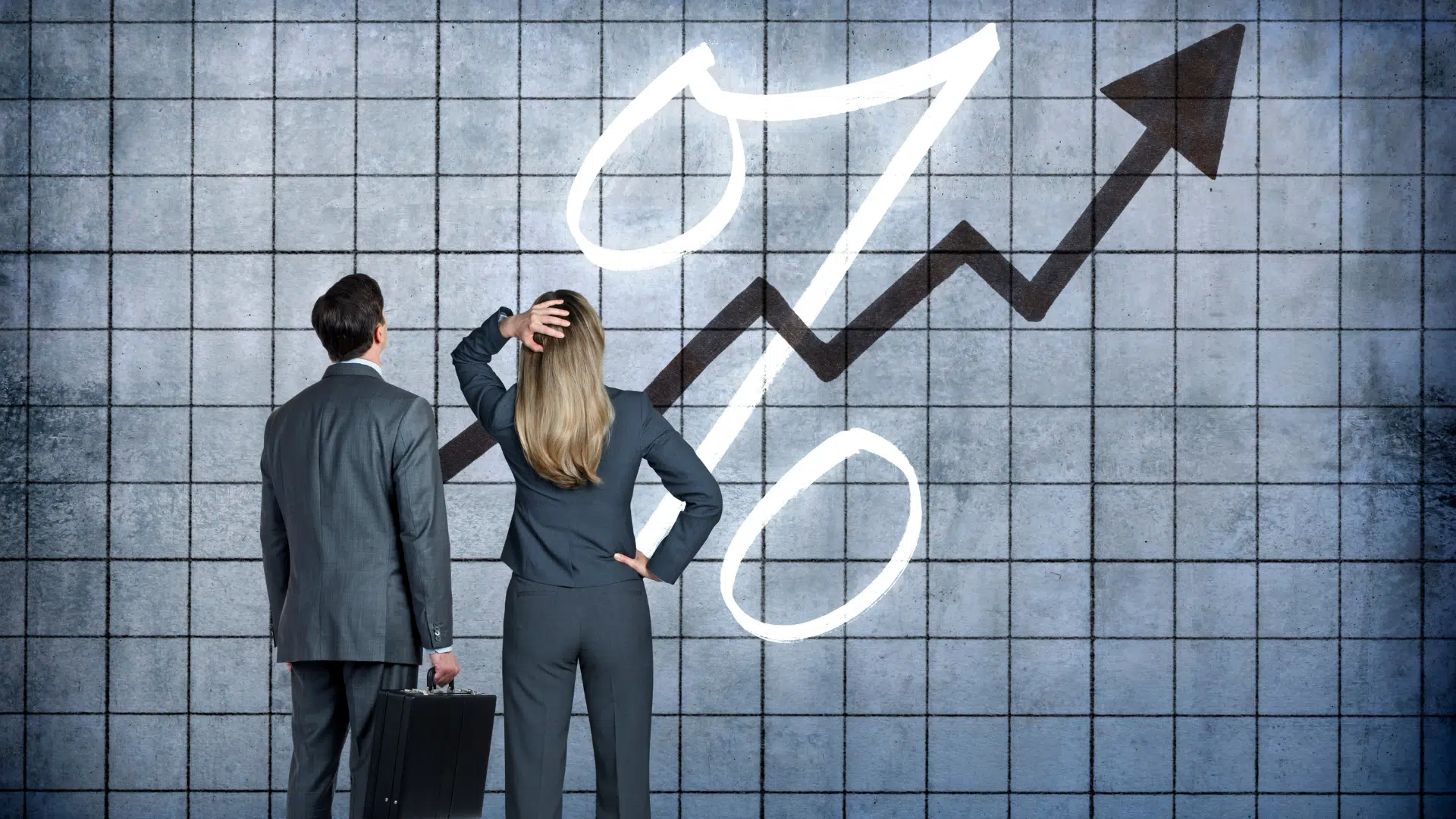 Two people looking at an upward-trending graph.